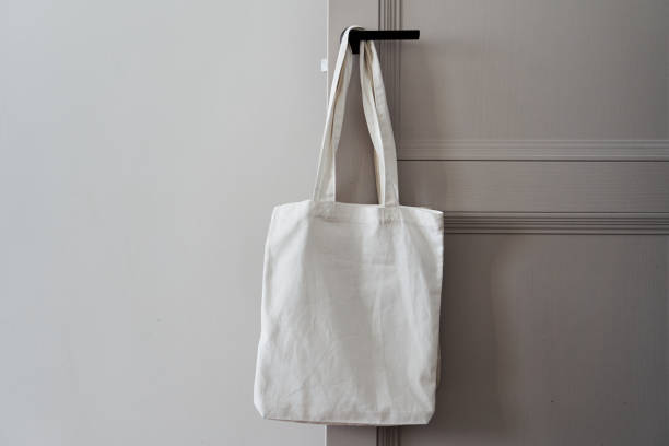 istock White eco friendly bag hanging on the door handle. Canvas tote bag 1300278908