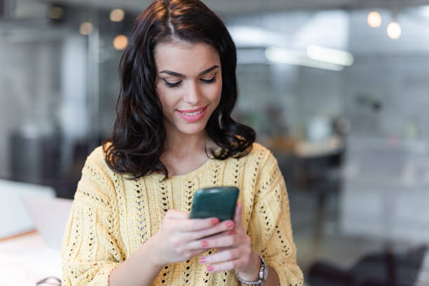 istock Young happy woman text messaging on cell phone. 1300280537