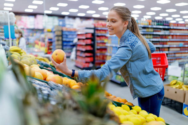 istock Woman reaching for red grapefruit in local market 1300280603