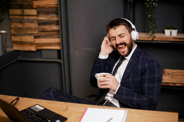 istock Young businessman with headphones singing at work. 1300280798