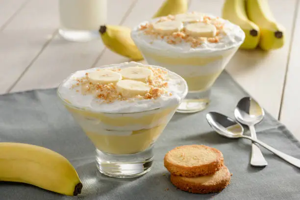 Photo of Delicious dessert with banana slices and cookie crumbs