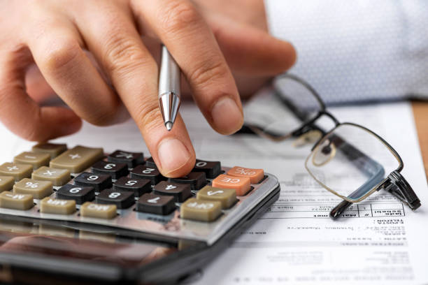 istock Close-up hand pen, calculator and invoice. Finance concept. 1300284048