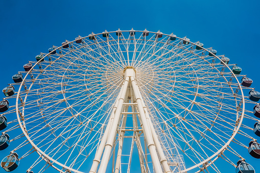 Ferris wheel and blue sky seen directly from below
