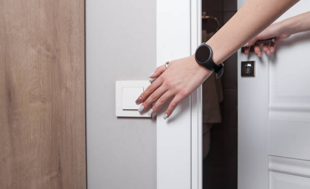 istock Female hand turning an electricity light switch on the wall. 1300286221