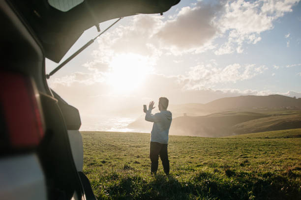 istock Young man video calling in a beautiful landscape 1300287154