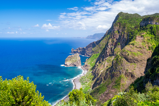 View over the Madeira coastline facing the Ilhéu da Viúva ou da Rocha do Navio during a beautiful summer day.