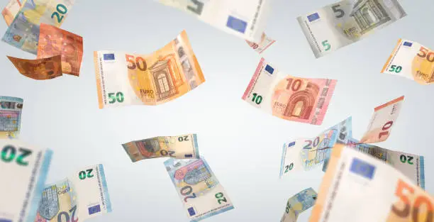 Many flying Euro banknotes on a neutral background.