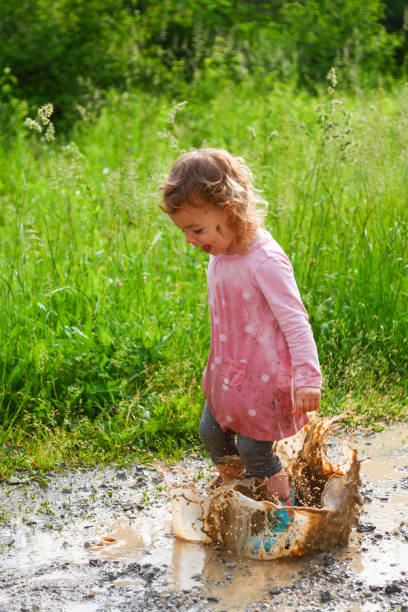 istock Happy girl jumping in a puddle 1300291454