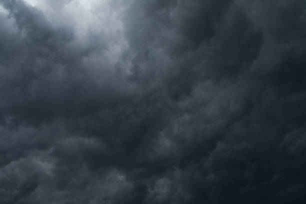 istock A dark sky filled with clouds and a small bright spot. 1300292207