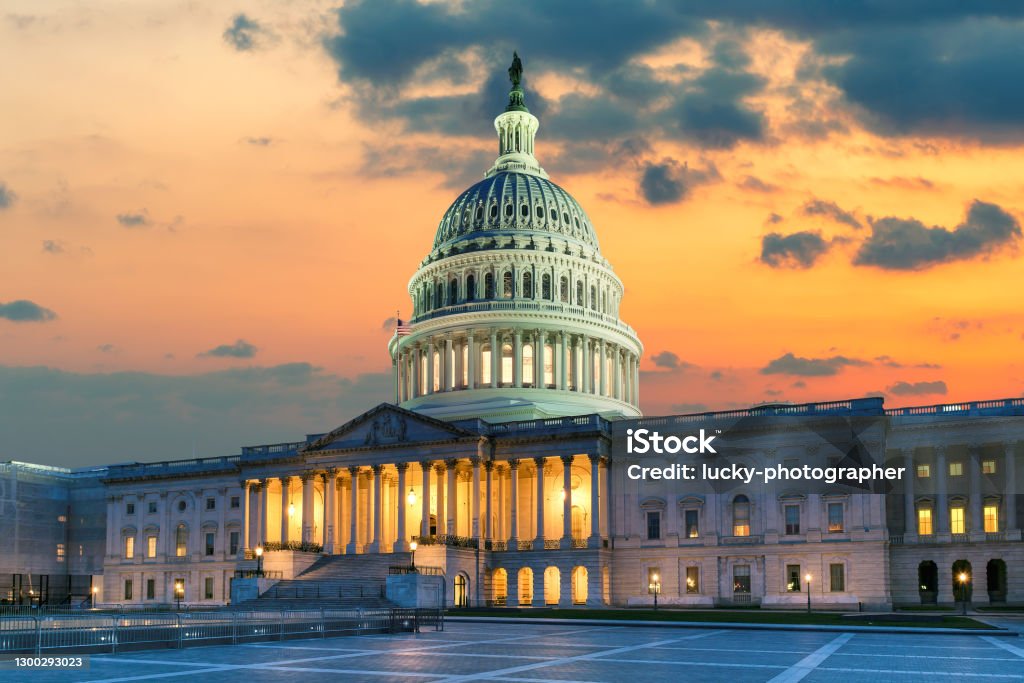 The United States Capitol Building in Washington DC at Sunset US Capitol Building at sunset with American flags is the home of the United States Congress in Washington D.C, USA. Capitol Building - Washington DC Stock Photo