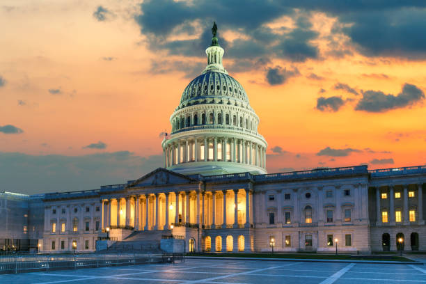 The United States Capitol Building in Washington DC at Sunset US Capitol Building at sunset with American flags is the home of the United States Congress in Washington D.C, USA. capitol building washington dc photos stock pictures, royalty-free photos & images