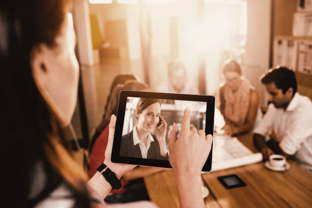 istock Composite image of businesswoman using digital tablet while discussing with colleagues 1300293616
