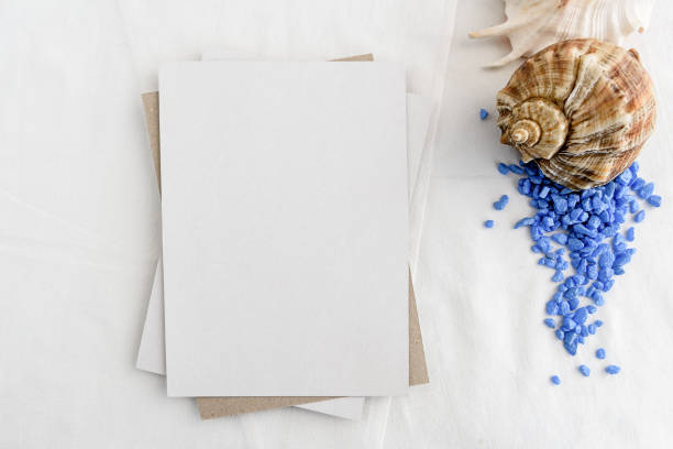 istock Fashionable stock stationery background - white map and seashells on a white table. Romantic background. Blank for an invitation card. 1300295536