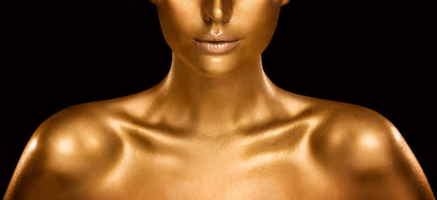 Fashion Gold Skin Beauty Woman Portrait. Face Model Golden Makeup. Gold Lips Make up and Shiny Body Paint over Black Fashion Gold Skin Beauty Woman Portrait. Close up Face Model Golden Makeup. Gold Lips Make up and Shiny Body Paint over Black Studio Baclground tanned body stock pictures, royalty-free photos & images