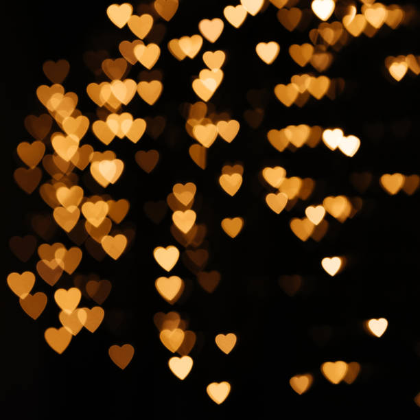 istock Gold background bokeh lights heart, valentine backgrounds, blurred sparkle for night backdrop. Defocused Theme of love banner. Loving, positive emotions. The concept of celebration and love. 1300300821