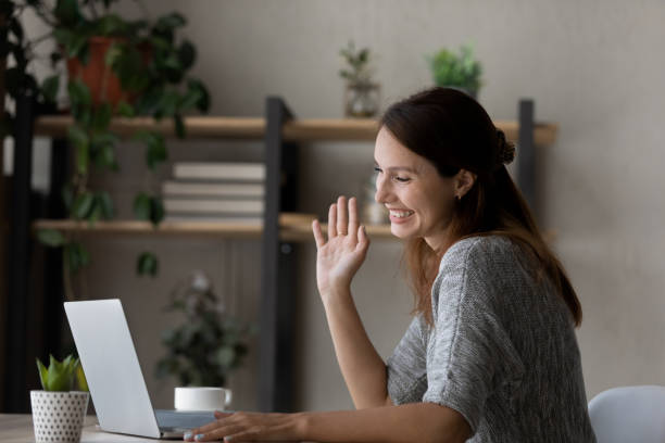 istock Smiling woman greeting talking on video call on laptop 1300302754