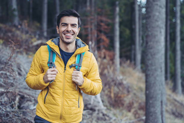 istock Smiling man with backpack on a footpath in the mountain 1300304438