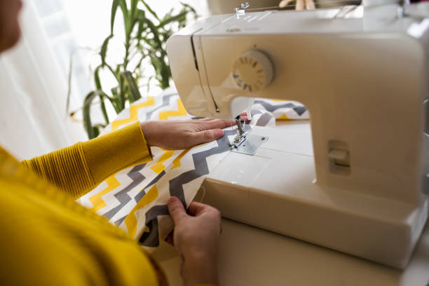 istock Woman sewing on a sewing machine at her home. 1300306895