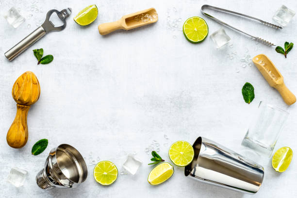 istock Bartender equipment and cocktail ingredietns - shaker, lime and ice. Overhead view 1300307510