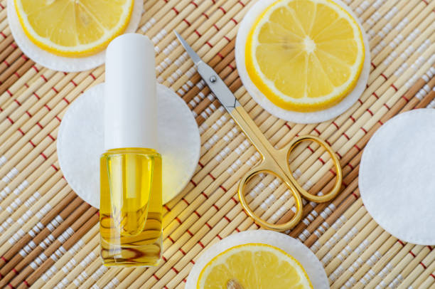 istock Small bottle with essential lemon oil (extract, tincture, infusion, perfume) and scissors. Aromatherapy, natural manicure and spa. Copy space 1300307616