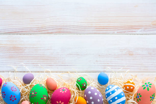 cornice colorata di uova di pasqua su tavolo bianco. spazio di copia - decoration fun in a row vibrant color foto e immagini stock