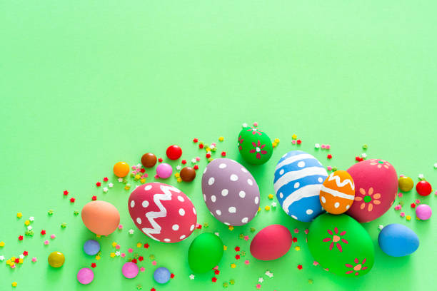istock Colorful Easter eggs with candies and sugar sprinkles on green background. Copy space 1300309818