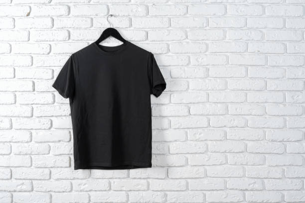 istock Black t-shirt hanging on a hanger against brick wall 1300311743