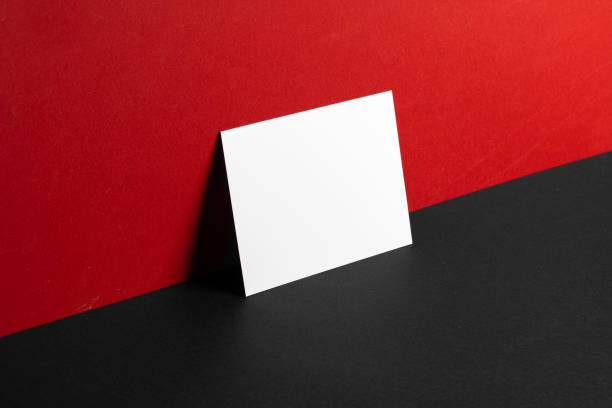 istock Blank white business cards on red and black paper background 1300313075