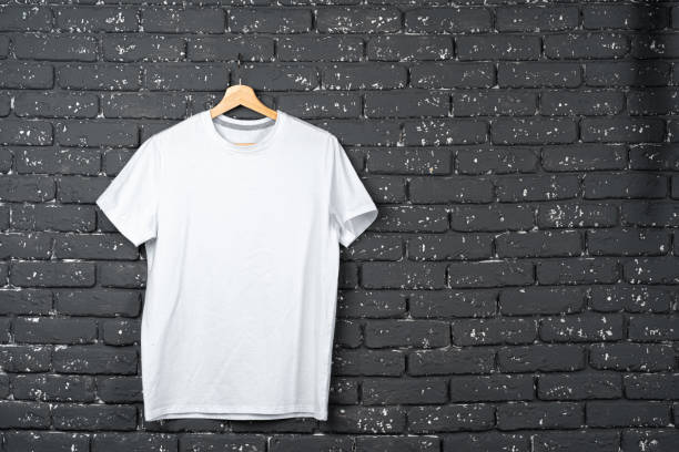 istock White t-shirt hanging on hanger against brick wall 1300313725