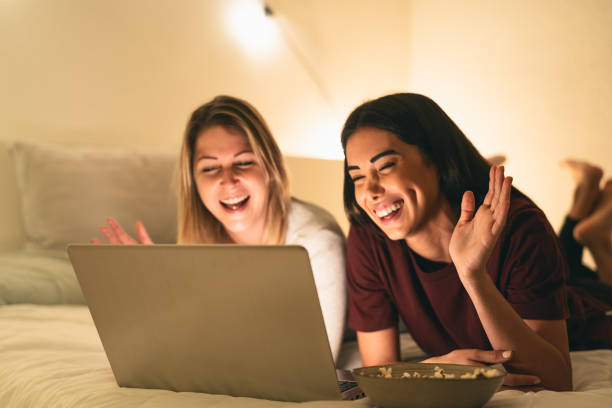 istock Young women having fun doing video call using laptop in bed during corona virus outbreak 1300315009
