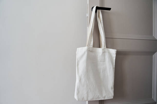 istock White eco friendly bag hanging on the door handle. Canvas tote bag 1300315489
