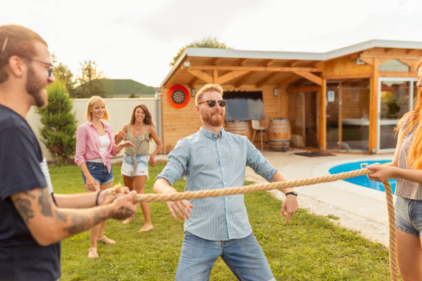 istock Friends doing limbo dance at summertime poolside party 1300317073