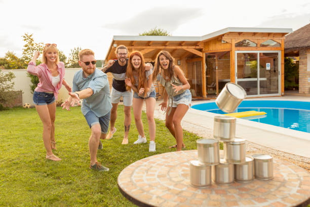 istock Friends playing knock down tin cans game 1300317798