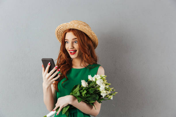 istock Redhead young surprised woman with flowers chatting 1300318378