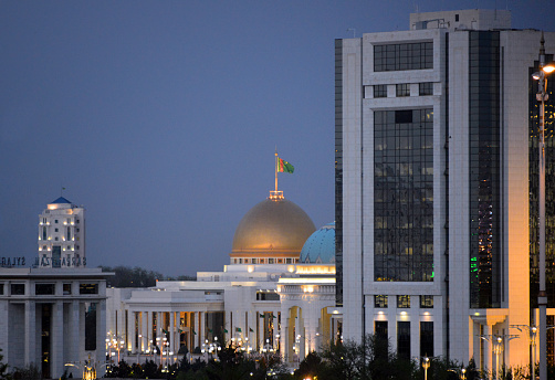 Ashgabat, Turkmenistan: evening view of the Central Bank of Turkmenistan tower and Turkmenbashy Palace, the old presidential palace of Saparmurat Niyazov, part of the Oguzhan Presidential Palace complex - Türkmenistanyn Merkezi Banky.