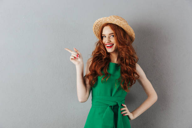 istock Happy redhead young woman pointing. 1300319634