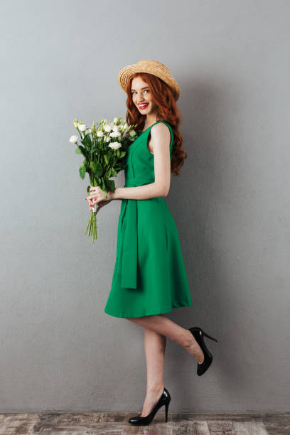 istock Redhead young happy woman with flowers. 1300319963