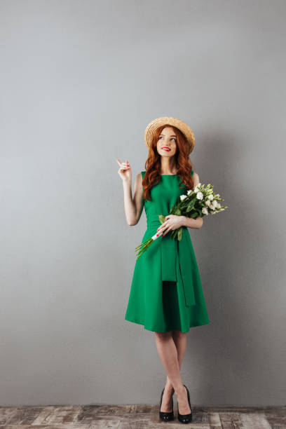 Cute redhead young woman pointing.
