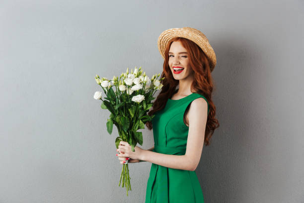 istock Redhead young cheerful woman with flowers. 1300321180