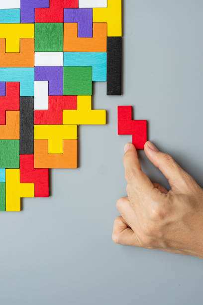 istock hand connecting geometric shape block with colorful wood puzzle pieces. logical thinking, business logic, Conundrum, decision, solutions, rational, mission, success, goals and strategy concepts 1300322517
