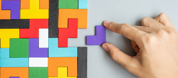 istock hand connecting geometric shape block with colorful wood puzzle pieces. logical thinking, business logic, Conundrum, decision, solutions, rational, mission, success, goals and strategy concepts 1300322604