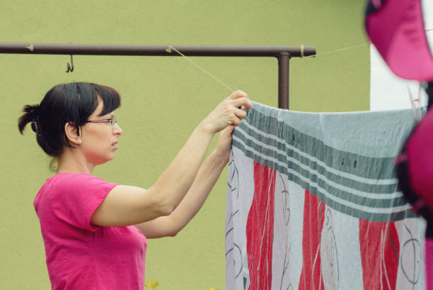 istock Woman hang laundry on clothesline strings 1300322723