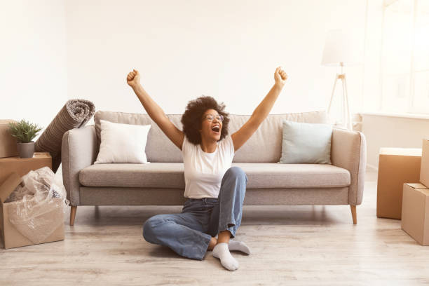 istock Joyful Black Woman Sitting Among Moving Boxes After Relocation Indoors 1300322980