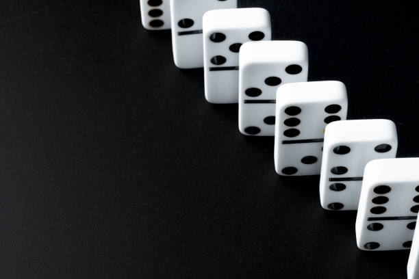 istock Domino pieces put in a row on black background 1300324039
