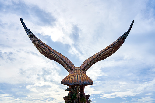 A sculpture of a red eagle spreading its wings. Popular tourist spot on Langkawi island. Langkawi, Malaysia - 07.18.2020