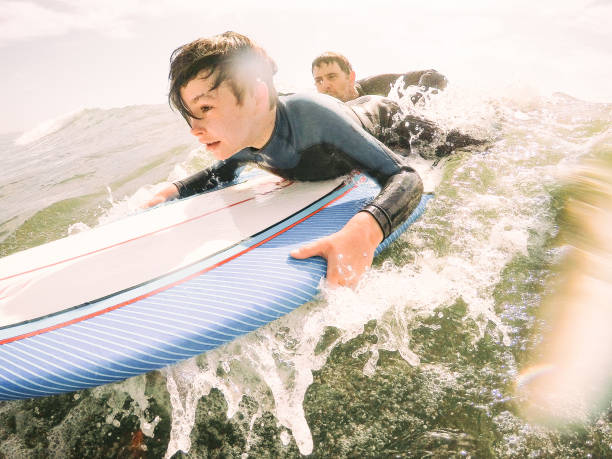 diversión de vacaciones de invierno en el sur de california - surfing beach family father fotografías e imágenes de stock