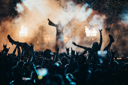 Shot of a crowd of people cheering the band on the stage