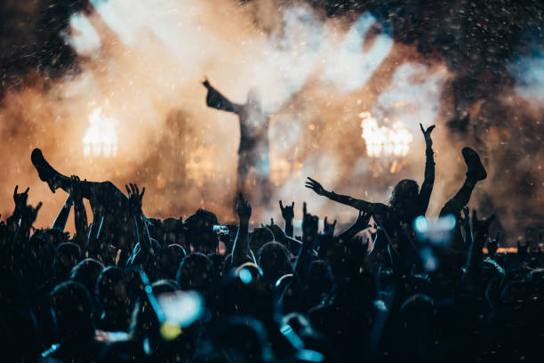 This concert is next level! Shot of a crowd of people cheering the band on the stage celebrity fans stock pictures, royalty-free photos & images