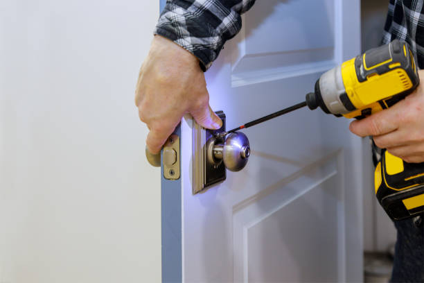 Master with screwdriver installs door new lock in house. Master with screwdriver installs access the room door new lock in house. door chain stock pictures, royalty-free photos & images