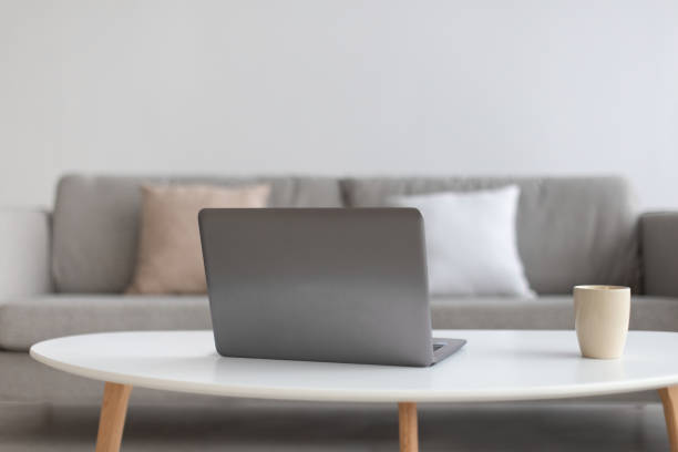 istock Workplace at home for remote work. Focus on laptop on white table with cup of hot drink 1300327560